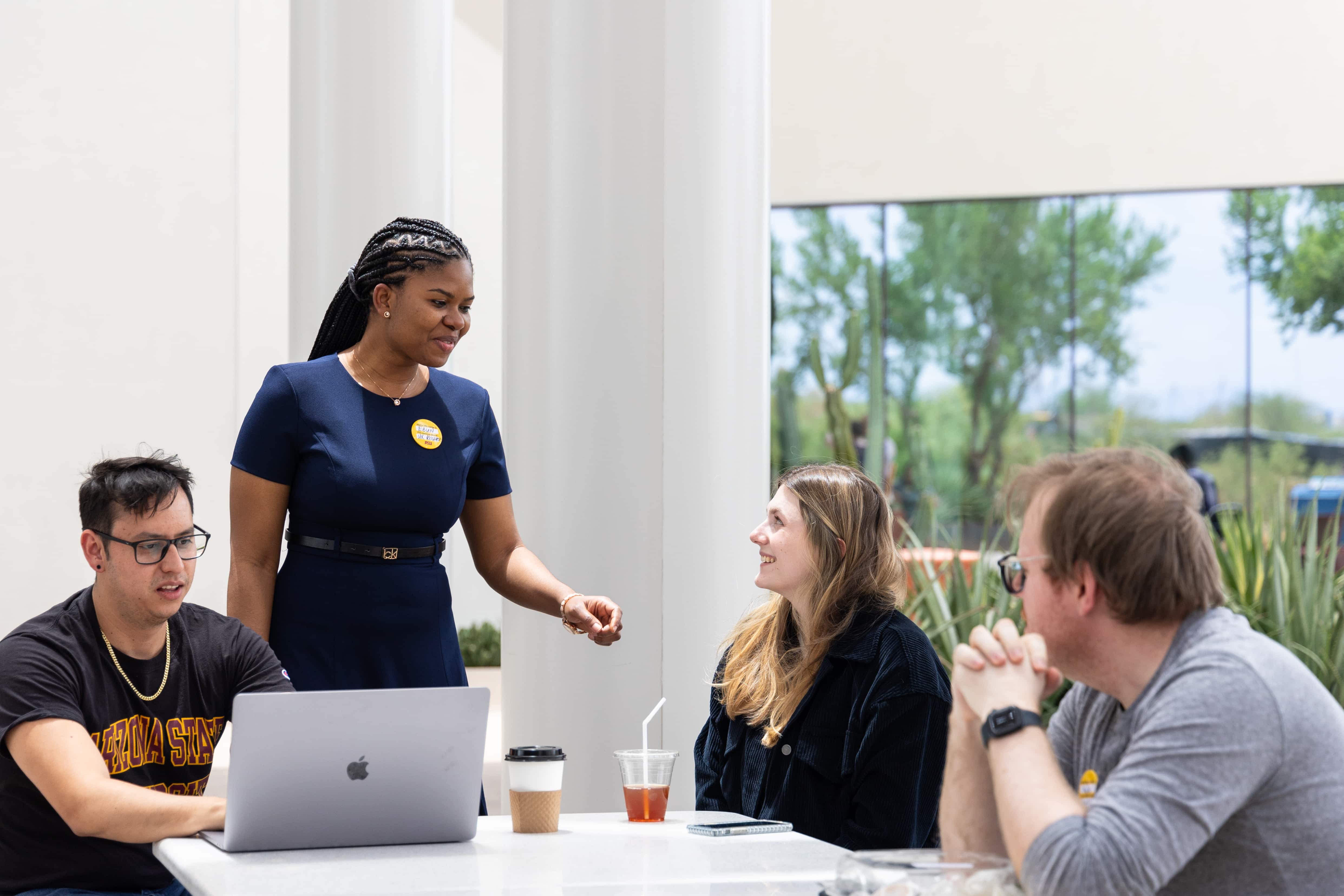 four students talking at a table